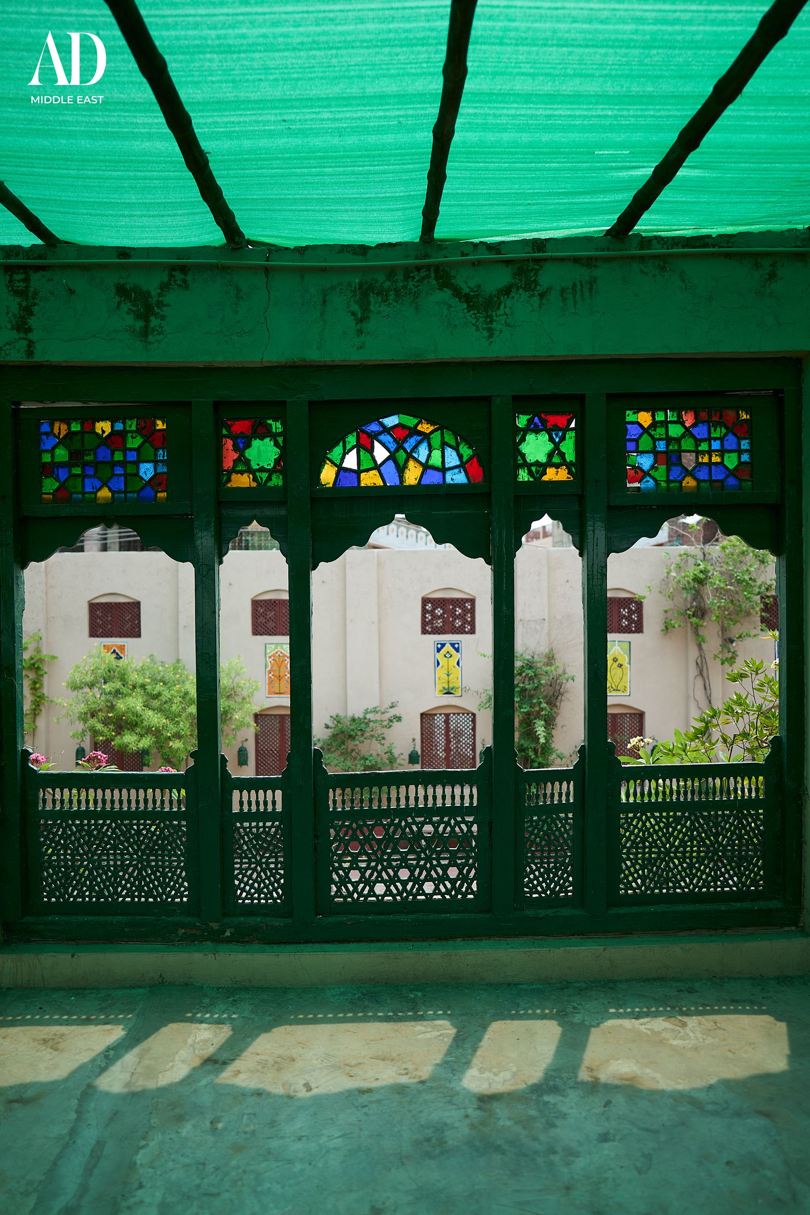Carved timberwork and jewel-toned stained glass framing the courtyard
